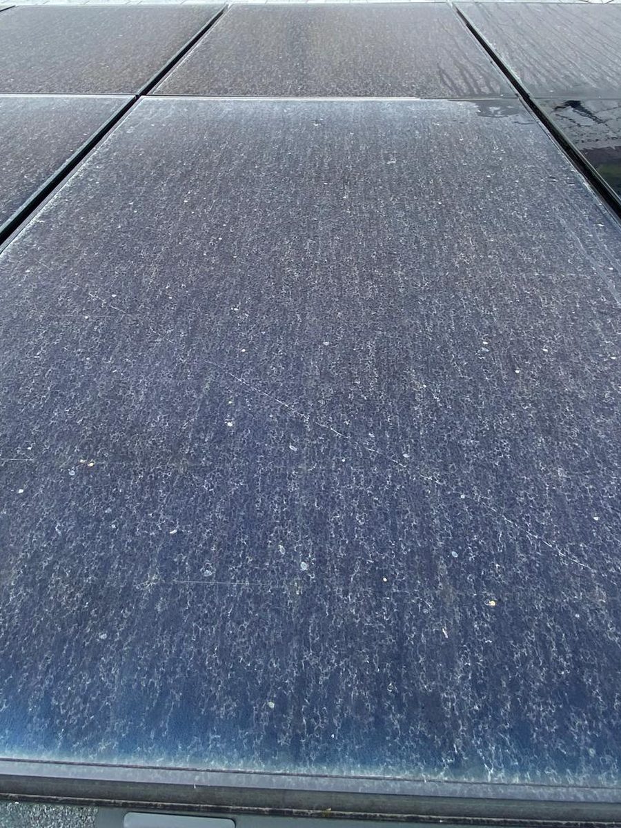 Dusty solar panel on a shingle roof, before cleaning